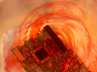 Computer circuit board floating in blood