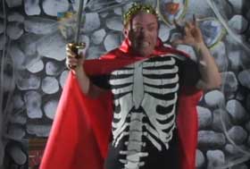 Horror host Charlemagne wearing a skeleton costume and red cape