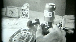 Man dialing a rotary phone while drinking a Tab