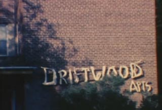 Brick apartment building with the words Driftwood Apts hanging on the outside
