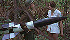 WWII soldier carrying missile talks to woman in white dress