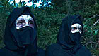 Two people covering their scarred faces with cloth