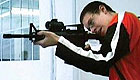Teenage boy shooting a rifle