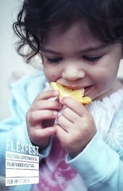 Little girl bites into an orange slice