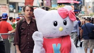A man stares at giant female cat costume on a New York City street
