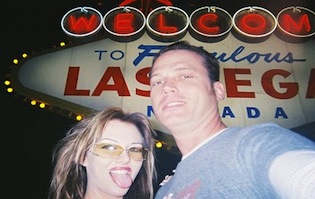 Adult film star Joe Blow and his girlfriend pose in front of the Las Vegas sign
