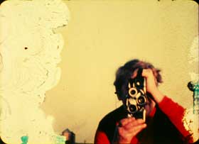 Marie Menken behind her Bolex movie camera