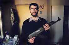 Filmmaker Usama Alshaibi poses with a rifle