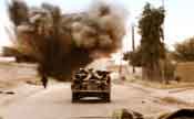 American Army vehicle driving through an explosion in Iraq
