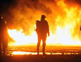 Fireman standing in front of a blazing fire