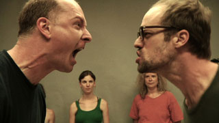 Two actors screaming at each other in a workshop