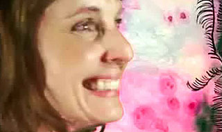 Woman smiling in front of a pink background