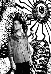 Black and white photo of Charles Pinion standing in front of a mural he painted