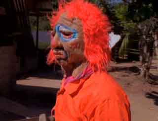 Man wearing a Halloween fright mask with an orange wig