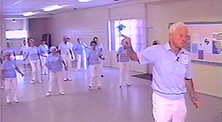 Elderly man leading elderly women in an exercise dance class