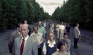 People standing on a dirt road in the middle of the woods