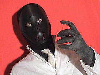 Menacing man wearing a black hockey mask in film still from The Slaves of Destructo