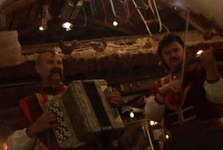 Two musicians, one playing an accordian and the other playing a violin