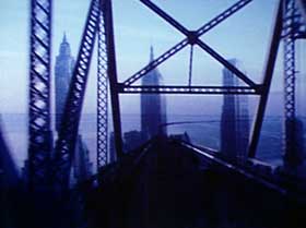 Film still from Bridges-Go-Round featuring a blue tinted bridge view of New York City