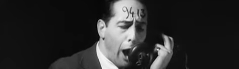 A man with the number 9413 written on his forehead yells into a telephone in Robert Florey/s film The Life and Death of 9413 — A Hollywood Extra.