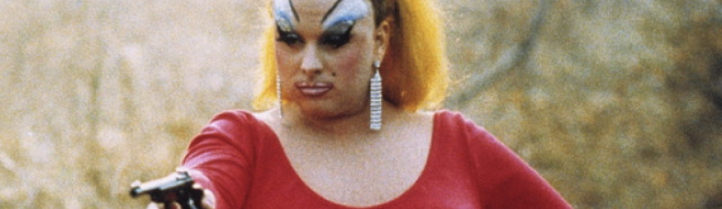 Divine points a gun in a still from the John Waters movie Pink Flamingos
