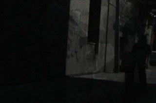 Shadow of a boy playing basketball in a dark alley