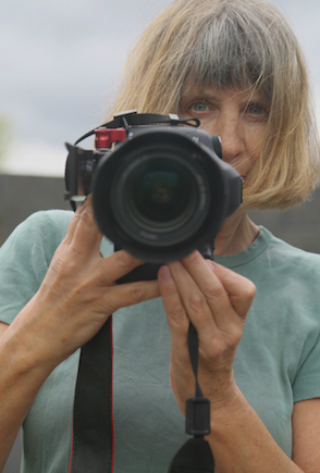 Portrait of filmmaker Vivienne Dick holding a camera