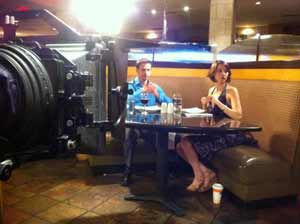Movie shoot in which a couple eating dinner in a restaurant are being filmed